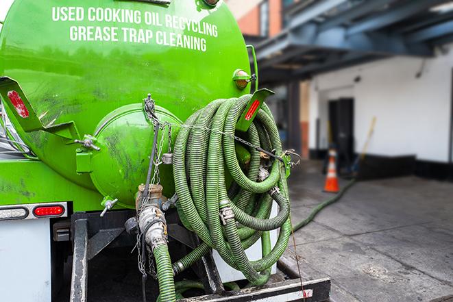 a technician pumping a grease trap in a commercial building in Grottoes